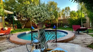 A poolside setting with a table, drinks, and a decorative centerpiece. - Relais Esmeralda (Lalla Takarkoust)