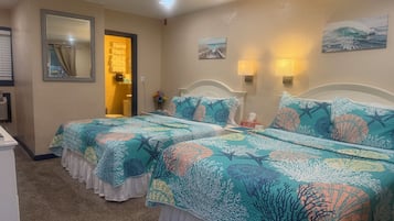 Une chambre d’hôtel avec deux lits, une salle de bain, un miroir et un tableau au mur.