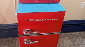 Un microondas rojo Comfee encima de un refrigerador rojo Frigidaire.