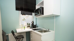 Une petite cuisine équipée comprenant un four à micro-ondes, un évier et un petit plan de travail.
