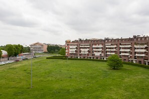 Un edificio residencial con varios balcones y un césped verde al frente.