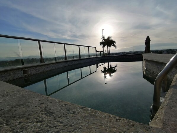 Una piscina al aire libre, sombrillas