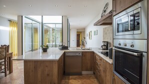 A modern kitchen with a dishwasher, double oven, and a large island. - Casa Serena | 6 Bedrooms | Country House |  Estoi (Estoi)