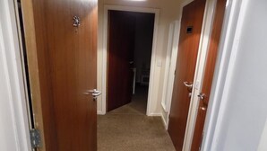 A narrow hallway with wooden doors, carpeted floor, and a ceiling light. - A Home From Home 3 (Plymouth)