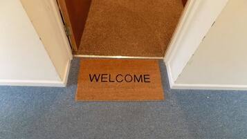 Un felpudo con la palabra "WELCOME" en un pasillo.