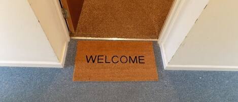 Un felpudo con la palabra "WELCOME" en un pasillo.