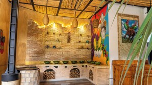 Uma cozinha rústica com parede de tijolos, luminárias pendentes e um mural.