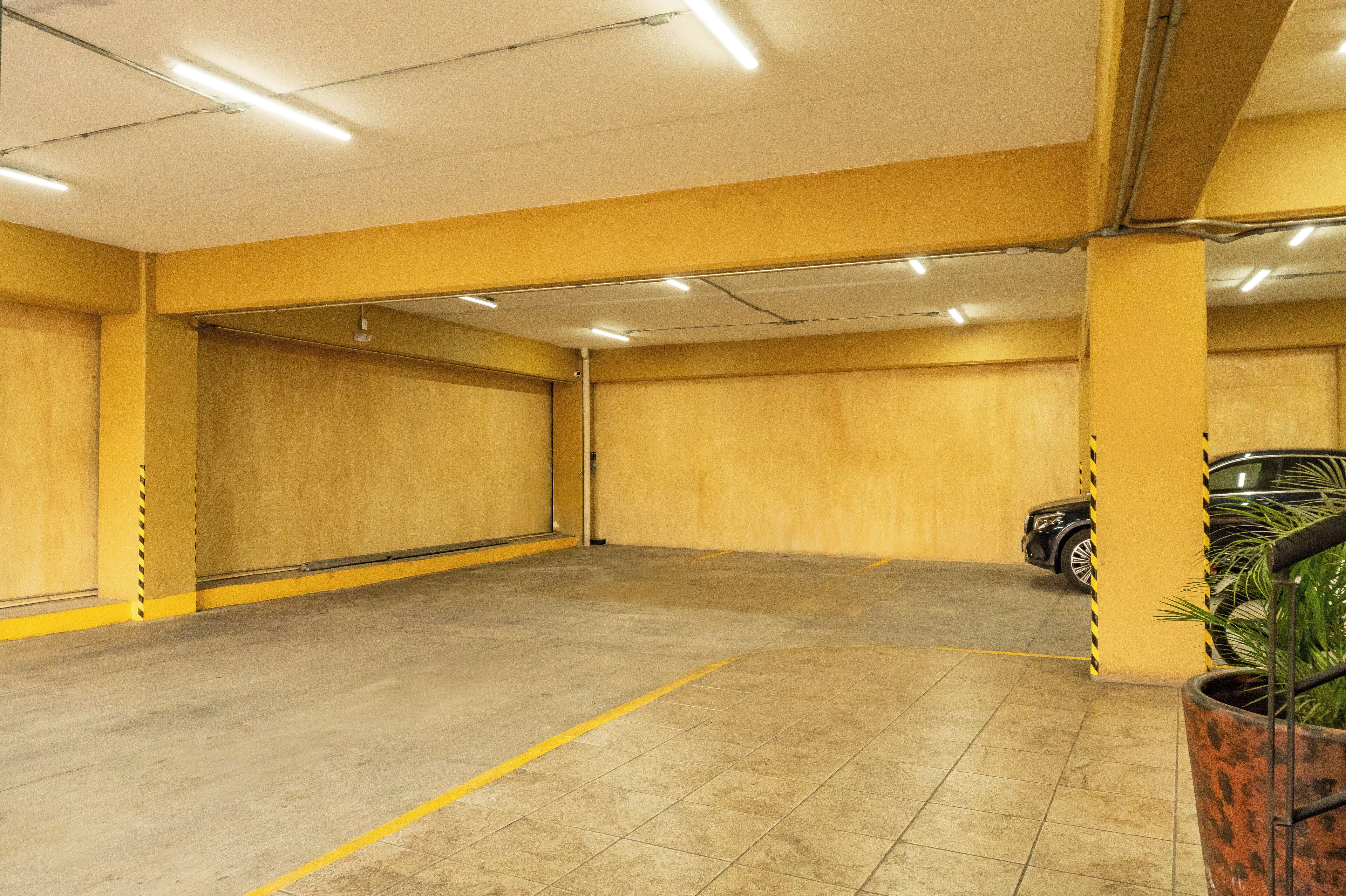 Un estacionamiento con paredes amarillas y piso de baldosas.