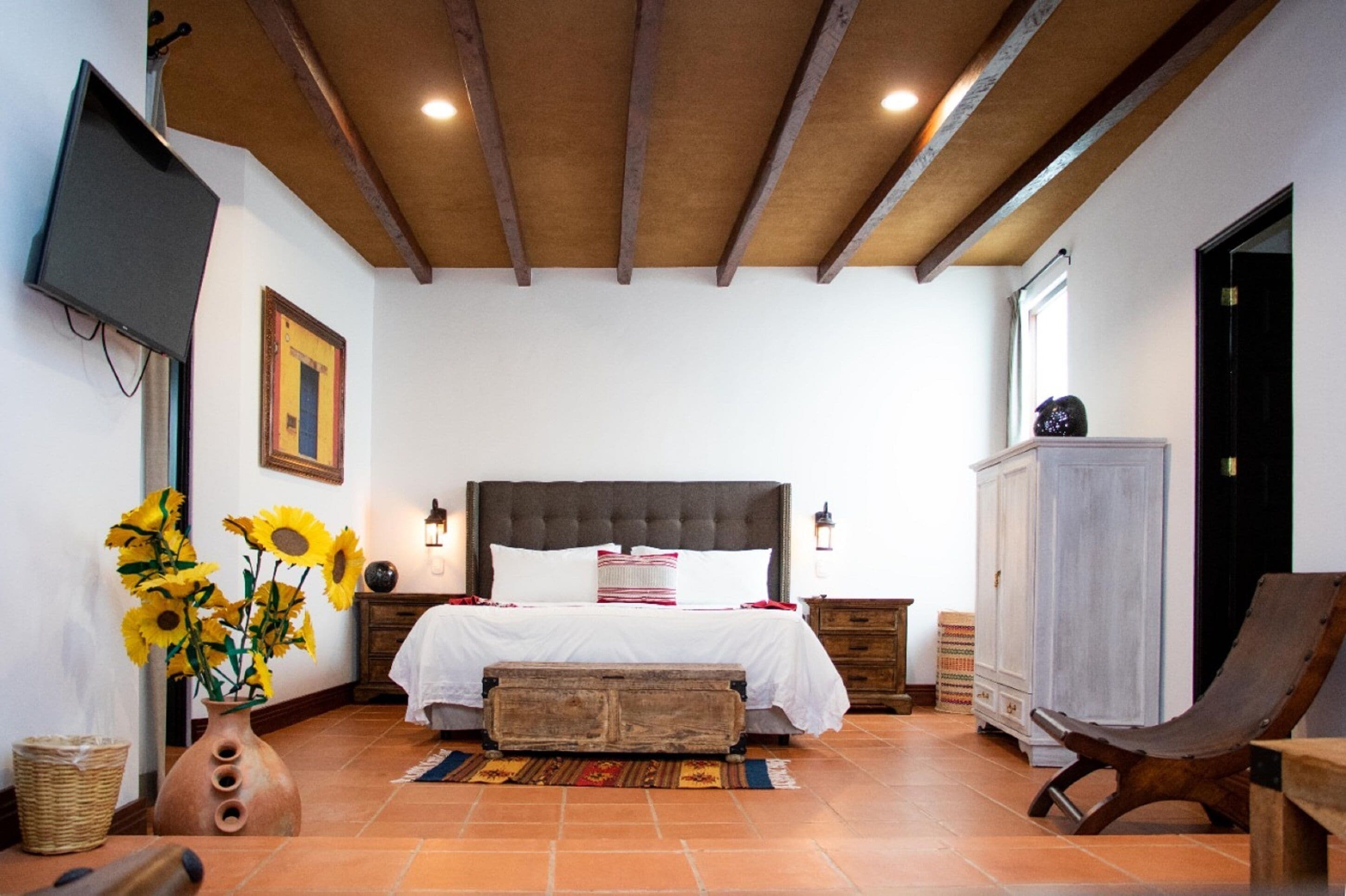 Une chambre à coucher avec un lit, une télévision, une armoire et une chaise.