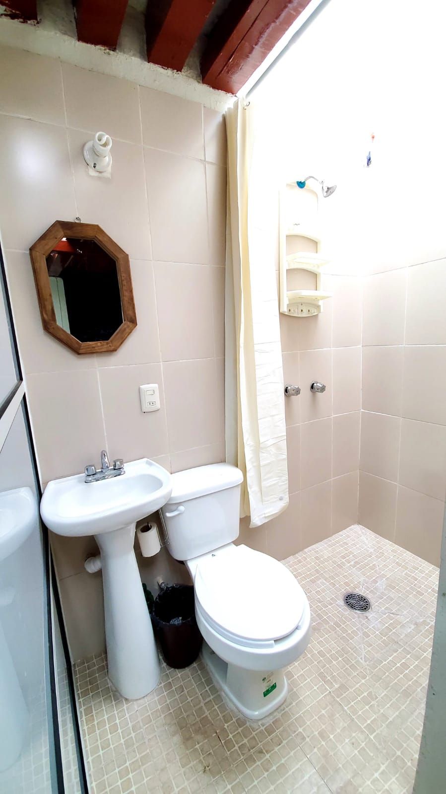 A small bathroom with a sink, toilet, and mirror.