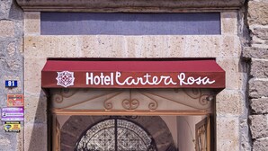 The entrance of Hotel Cartera Rosa with a wrought iron gate and potted plants. - Hotel Cantera Rosa (Morelia)