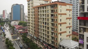 Un immeuble à plusieurs étages doté de balcons, une rue en contrebas et d’autres bâtiments en arrière-plan.