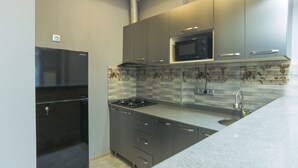 Une cuisine moderne équipée d’un four à micro-ondes encastré, d  ’une cuisinière à gaz et d’appareils électroménagers en acier inoxydable.