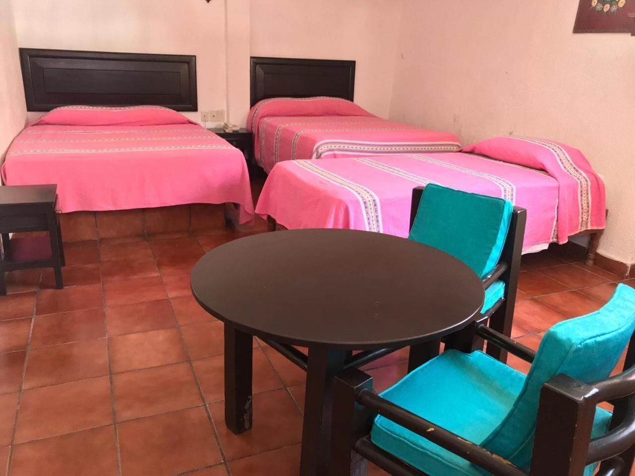 A room with two beds, a round table, and two chairs.