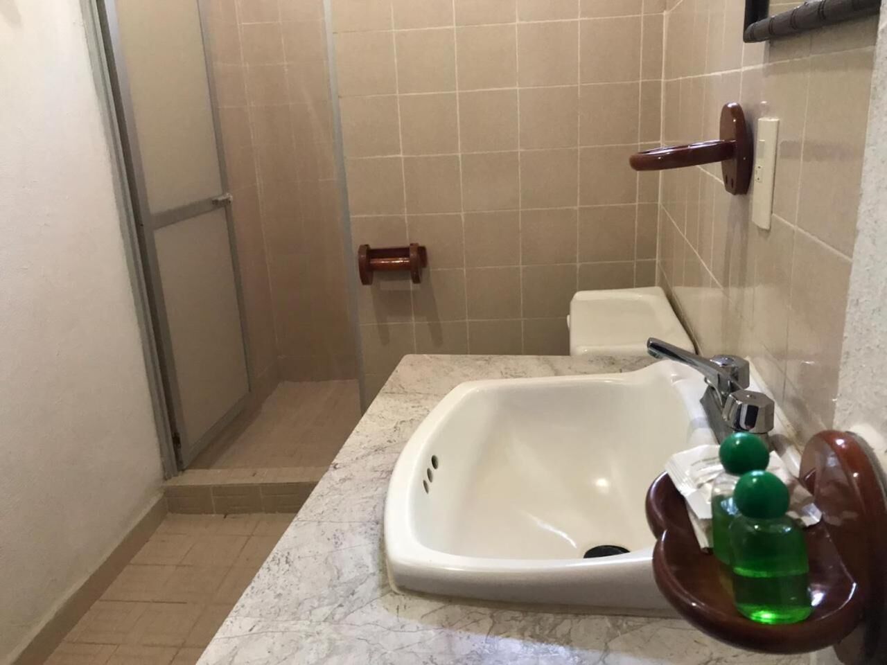 A bathroom with a white sink, a mirror, and a shower door.