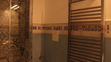 An elevator with a sign that reads "SE IO POTESSI FAREI SE NE FAREI" and a metal door with horizontal bars.