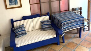 A room with a blue sofa, a small table, and a decorative hanging light fixture. - Quinto Sol 2 Departamento (San Miguel de Allende)
