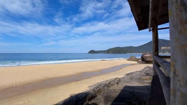 A beach with clear skies and calm water. - Pousada Naturale (Paraty)