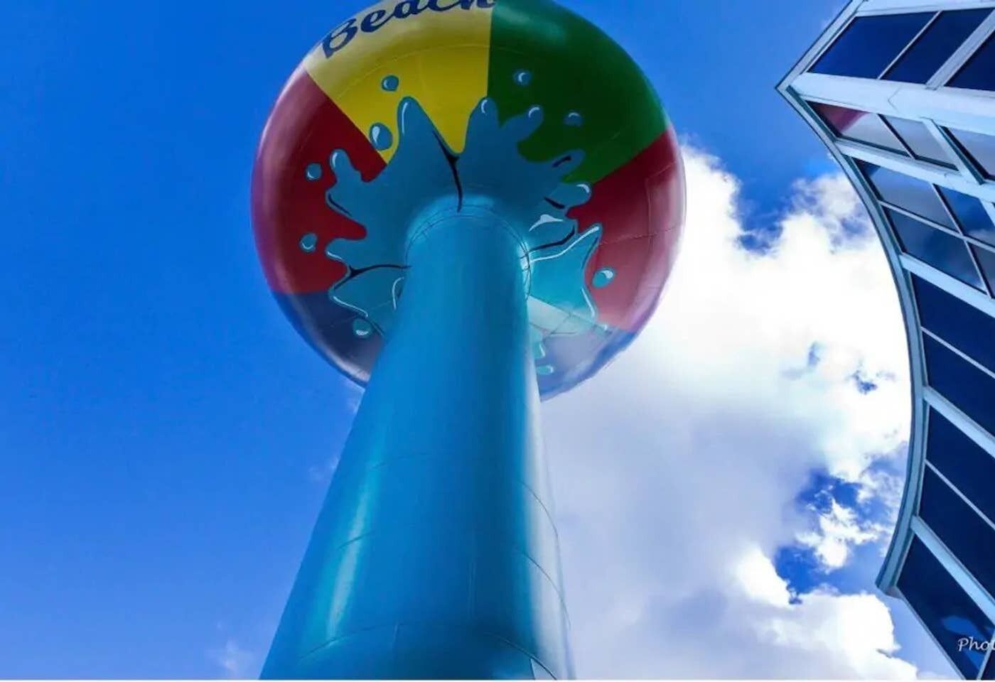 Una torre de agua colorida con una estructura transparente y una base azul.