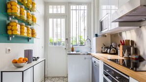 A compact kitchen with a white door, a window, and a countertop with a sink.