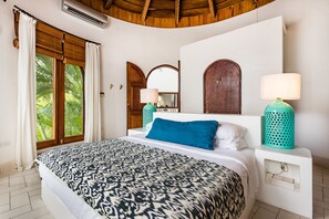 A bedroom with a bed, two wall-mounted lamps, a window with curtains, and a wooden ceiling. - Flamingo Blu House (Santa Cruz)