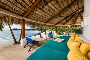A covered outdoor seating area with a pool, lounge chairs, and a sofa. - Flamingo Blu House (Santa Cruz)