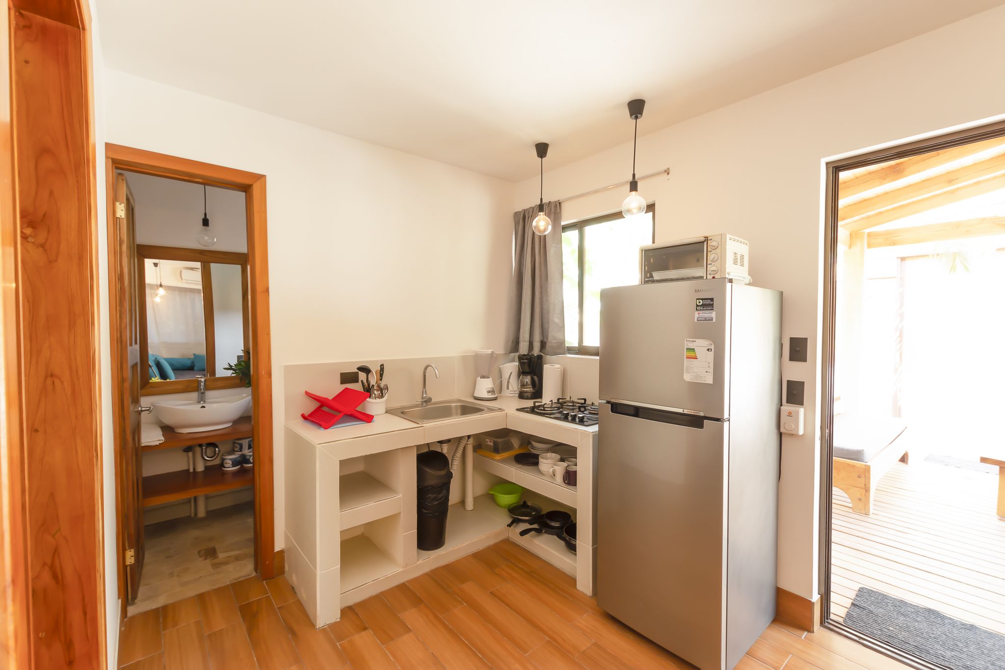 A compact kitchen with a sink, stove, and microwave.