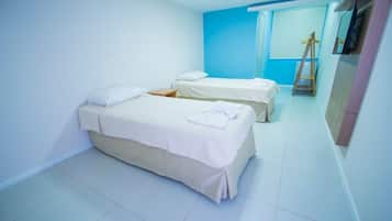 Habitación de hotel con dos camas, un armario y un espejo.