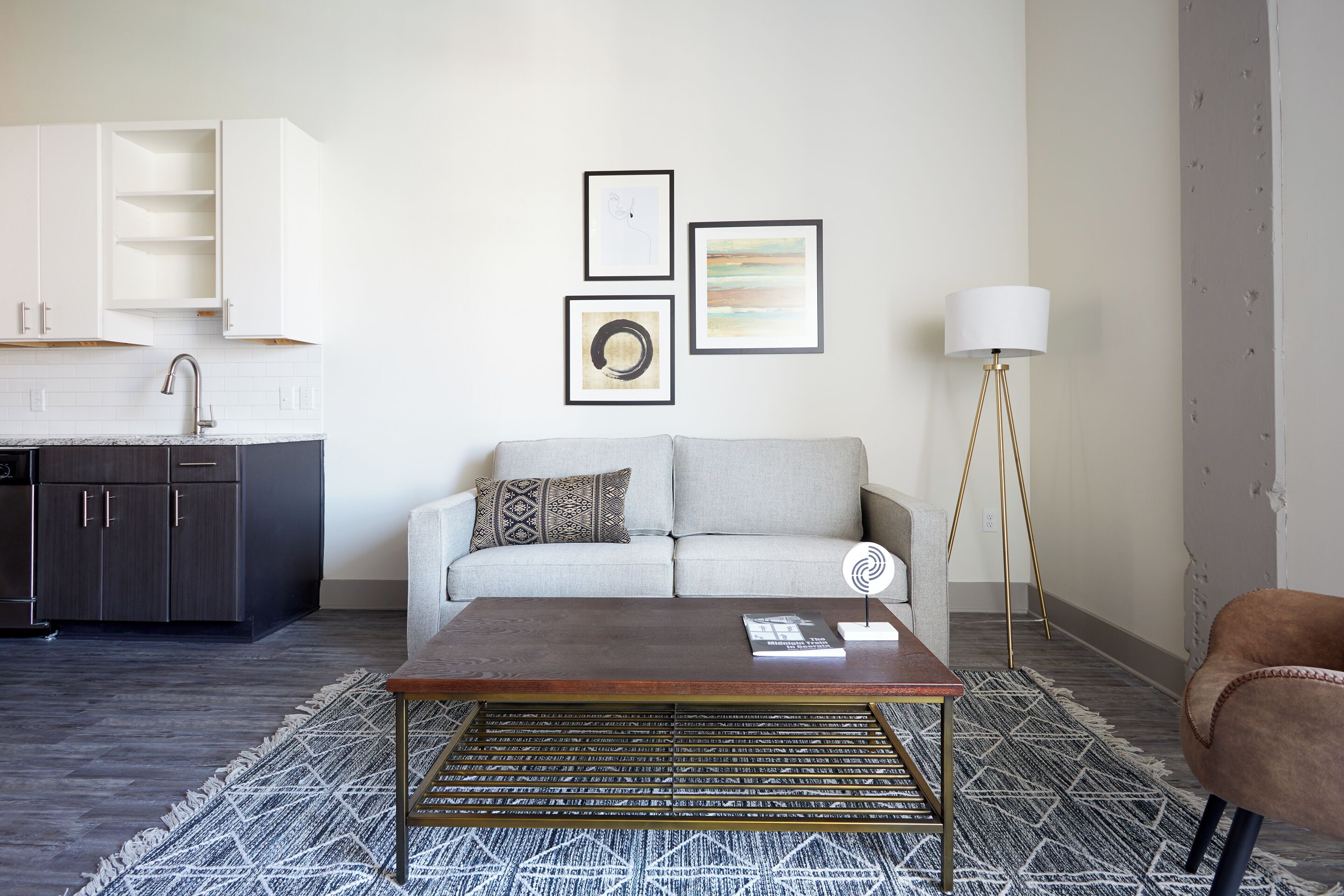 Un salon moderne avec un canapé, une table basse et des œuvres d’art accrochées au mur.