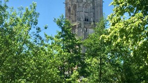 A historic cathedral with intricate Gothic architecture, surrounded by lush green trees. - Jolie halte normande (Balines)