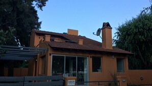 A modern house with a tiled roof, large windows, and a satellite dish. - Alojamiento La Roja (Chascomus)