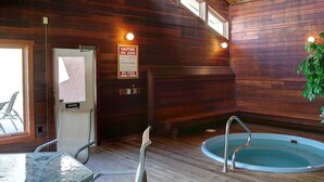 A spa area with wooden walls, a pool, and a caution sign for spa users. - Mountain Village 2 Level Steps to Ski (Steamboat Springs)