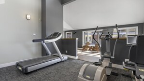 A home gym with a treadmill, elliptical, and weight machine. - Mountain Village 2 Level Steps to Ski (Steamboat Springs)