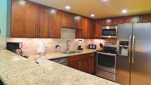 A kitchen with wooden cabinets, granite countertops, stainless steel appliances, and recessed ceiling lights. - Lift Tickets Newly Remodeled Sleeps 8 Pool, Hot Tubs,fireplace, Private Deck (Steamboat Springs)