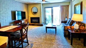 A living room with a fireplace, a television, a sofa, and a dining area. - Private Deck Mountain Views Babbling Creek Sleeps 4 (Steamboat Springs)