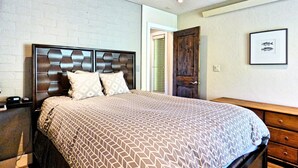 A bedroom with a large bed, a wooden headboard, a ceiling fan, and a framed picture on the wall. - Private Deck Mountain Views Babbling Creek Sleeps 4 (Steamboat Springs)
