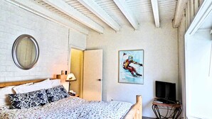 A bedroom with a bed, a mirror, a painting, a television, and a door. - Lift Tickets Near Ski Hot Tubs Wifi Fireplace, Multi-level Unit (Steamboat Springs)