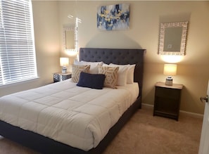 Cozy retreat with a large bed, bedside tables, and a large mirror above.