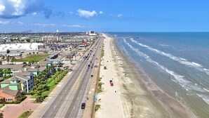 Eine Küstenstraße mit Strand auf der einen Seite und Gebäuden auf der anderen.