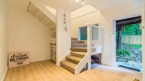 Un escalier menant à un deuxième étage, d’où l’on peut admirer un jardin.