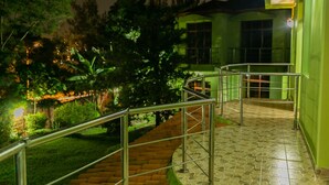 A staircase with metal railings leading to a building with a green exterior. - Perle Boutique Hotel (Kigali)