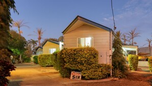 Une maison de plain-pied avec un panneau indiquant « RALENTISSEMENT, 5 KM » placé à l’entrée de l’allée.