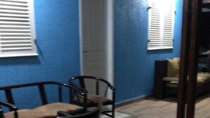 Ein Zimmer mit blauer Wand, einer Holztür und einem Essbereich mit Tisch und Stühlen.