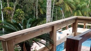 Eine Holzterrasse mit einem Pool im Hintergrund.