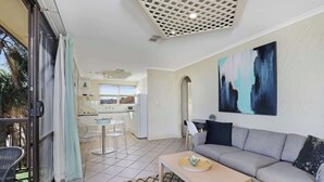 Een moderne woonkamer met een bank, salontafel en kunstwerk aan de muur.