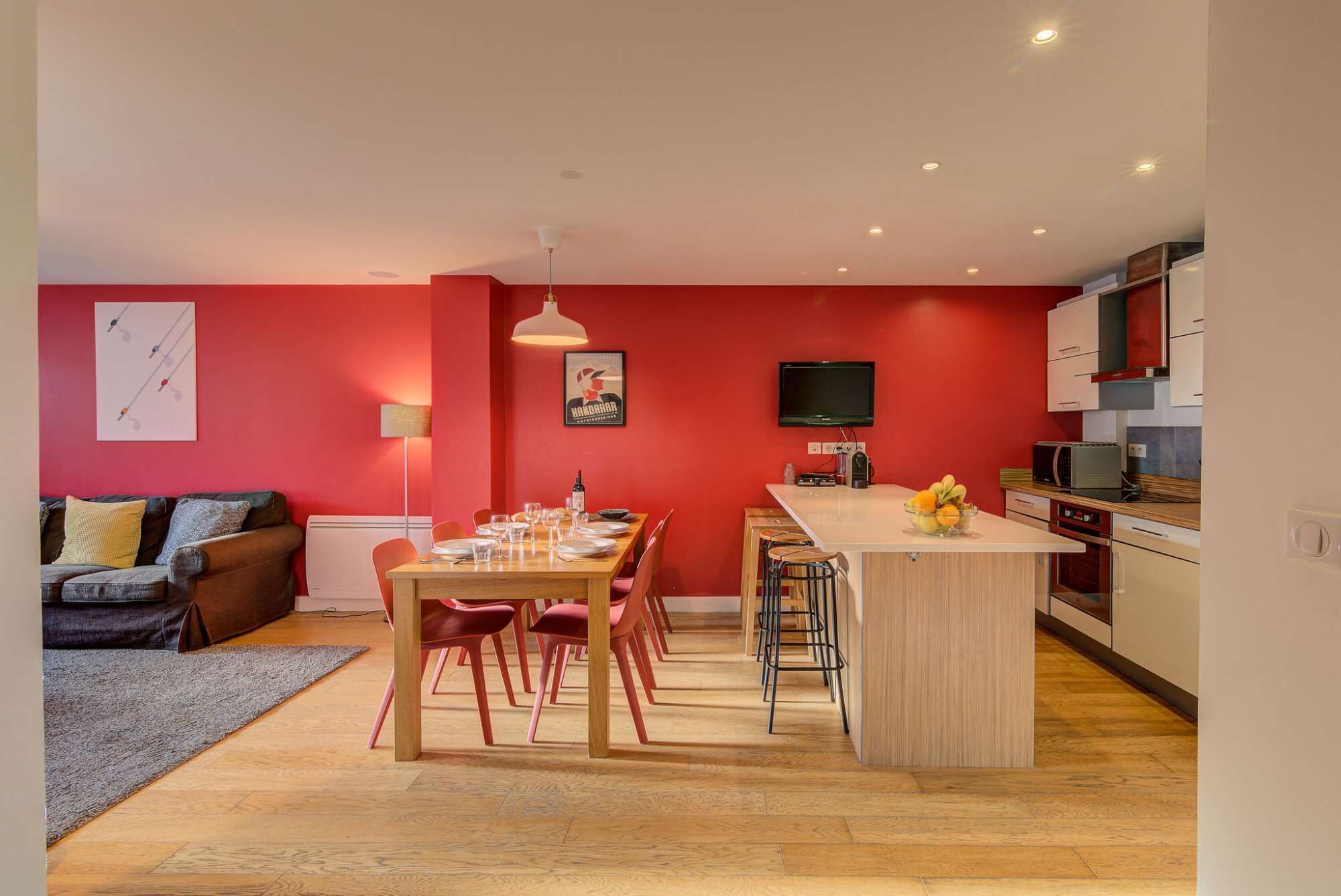A modern apartment with a dining area, kitchen, and living space.