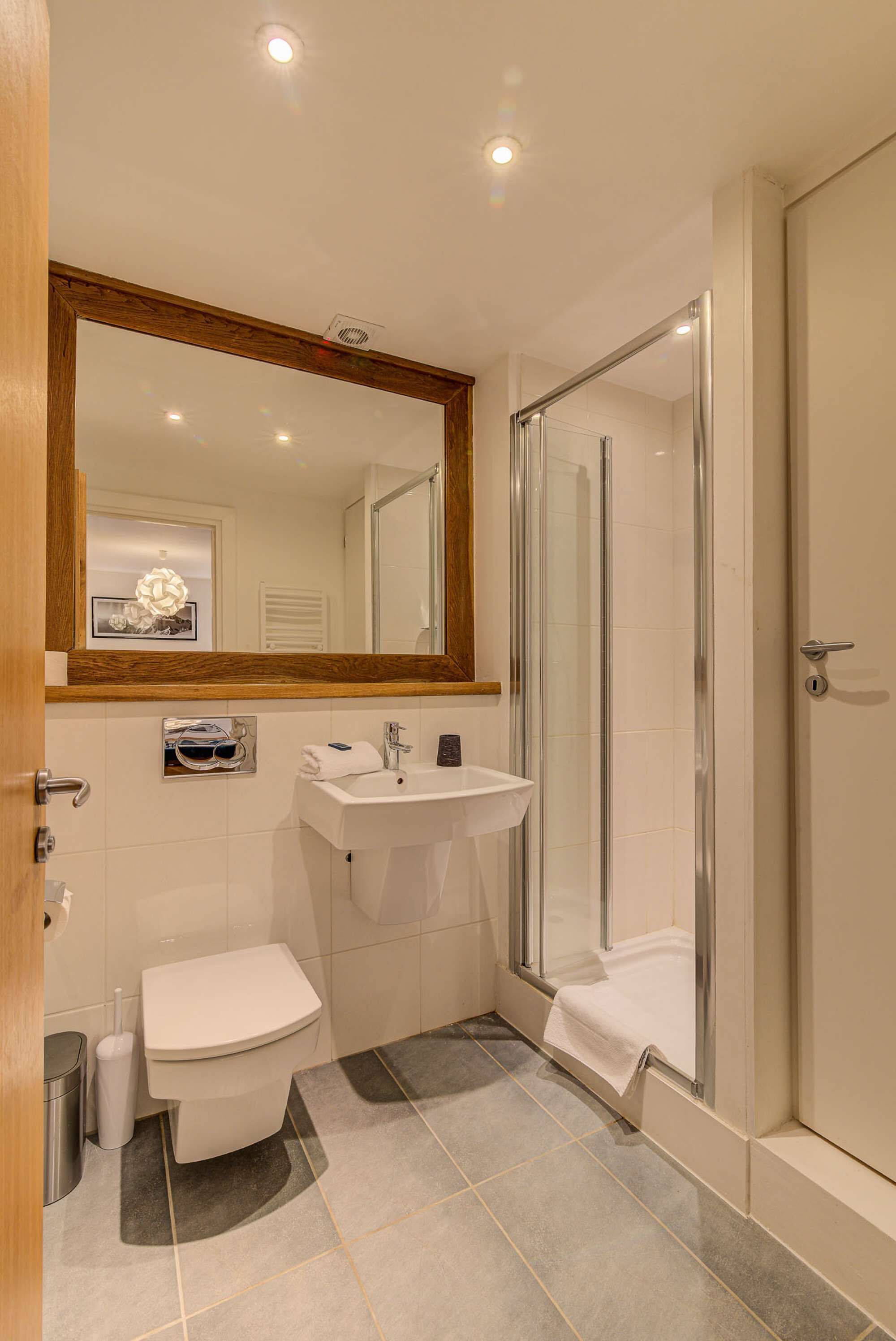 Un baño con inodoro, lavamanos y ducha.