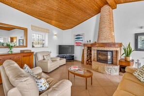 A living room with a fireplace, a television, and a sofa.