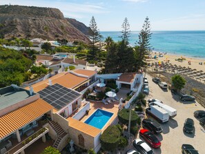 Une propriété située sur la côte, dotée d’une piscine, de panneaux solaires et offrant une vue sur la plage.