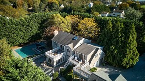 Ein geräumiges, zweistöckiges Haus mit Swimmingpool, mehreren Terrassen und einem gepflegten Garten.